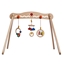 Houten babygym op 4 houten poten. Eraan hangen 3 veelkleurige babyspeeltjes: rammelaars met metalen belletjes of houten ringetjes.