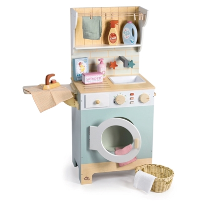 Lichtblauwe speelgoed wasmachine in hout met wasdraad, strijkplank, strijkijzer, wasmand en wasproducten.